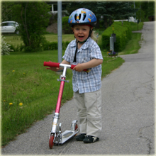 En halvarg sparkcykel åkande liten kille på väg att äta studentmiddag